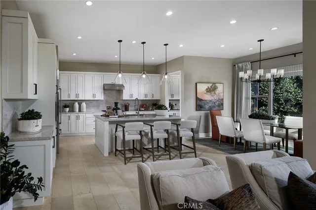 a large kitchen with lots of furniture and stainless steel appliances