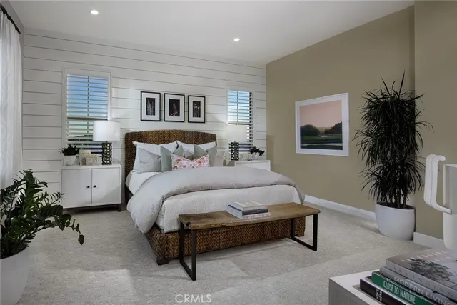 a spacious bedroom with a bed and a potted plant