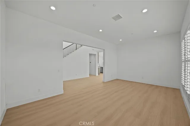 a view of an empty room with closet and a window