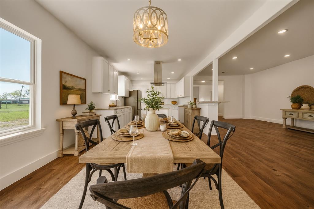 a view of a dining room with furniture a chandelier and wooden floor