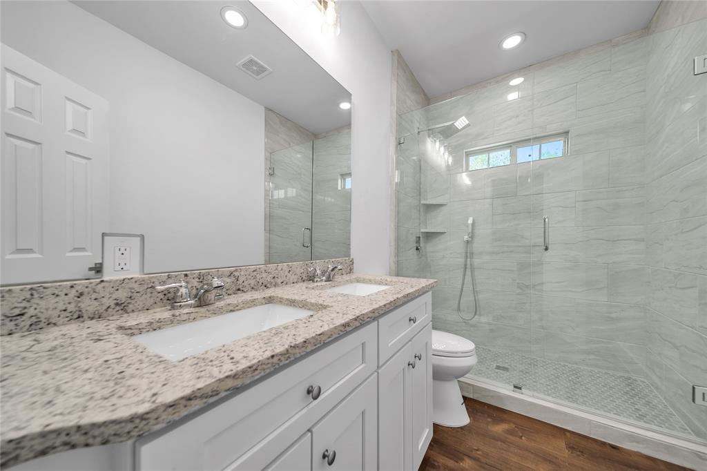 1128 Newton Road Ferris, TX 75125 - Photo 11 of 19 Full bath with dark wood finished floors, a stall shower, double vanity, and recessed lighting