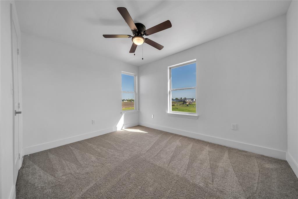 1128 Newton Road Ferris, TX 75125 - Photo 13 of 19 Spare room featuring light colored carpet and a ceiling fan