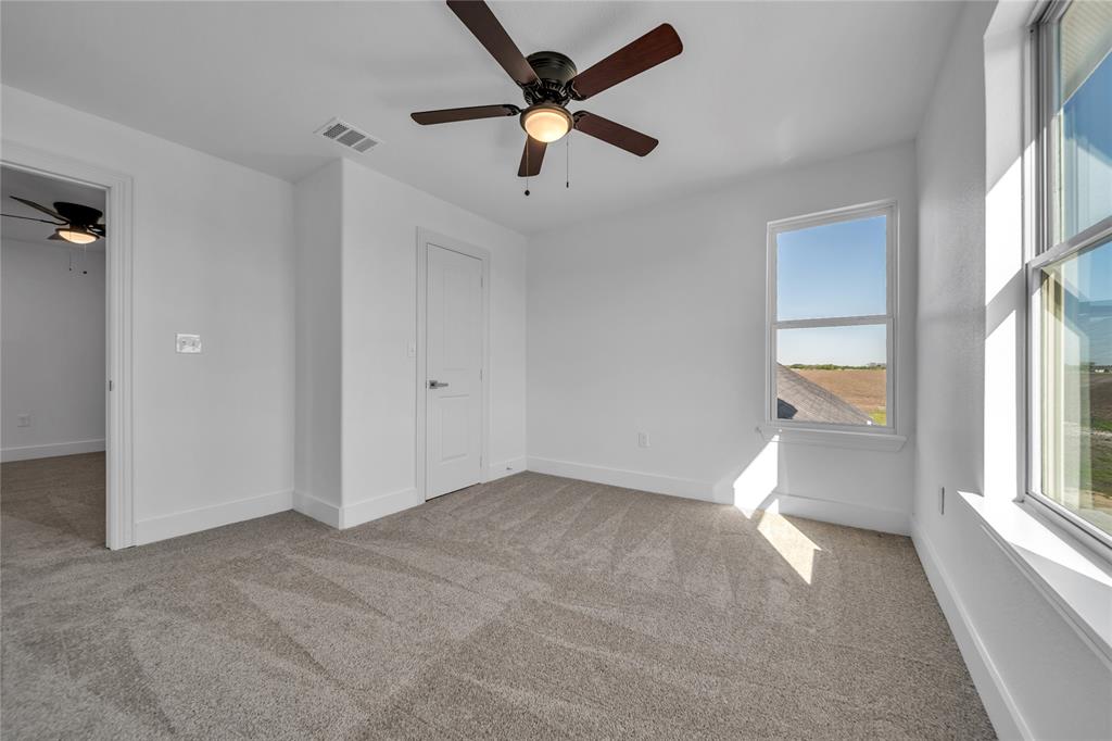 1128 Newton Road Ferris, TX 75125 - Photo 14 of 19 Unfurnished bedroom featuring light carpet and a ceiling fan