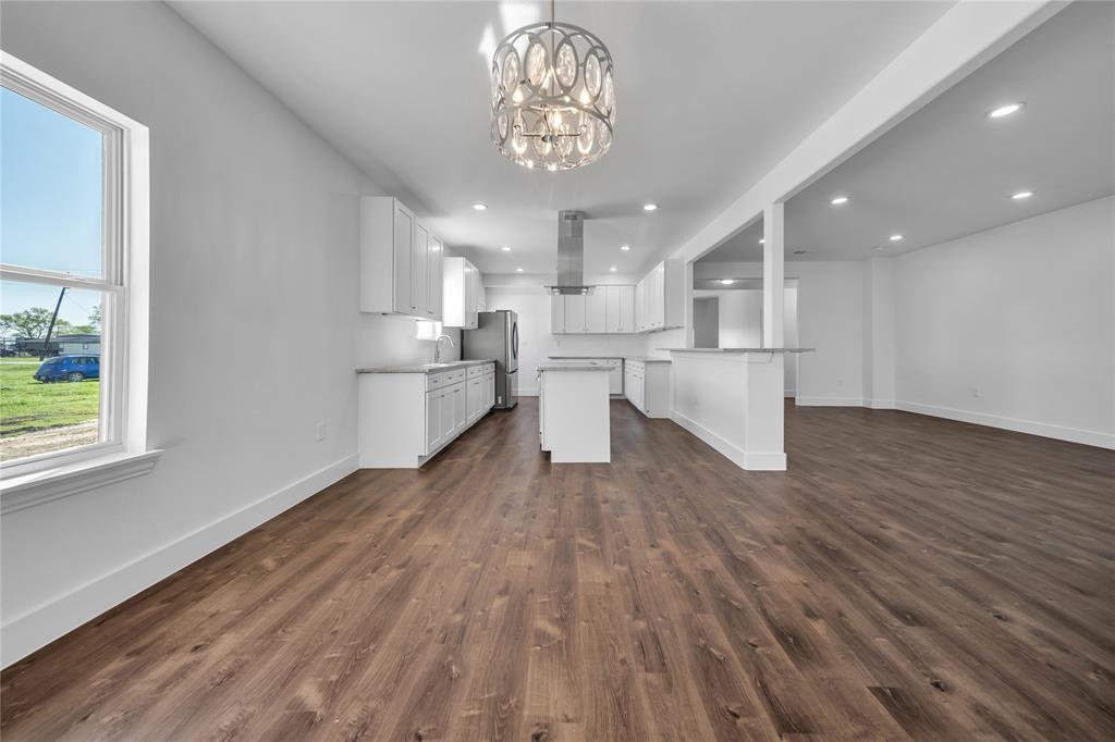 1128 Newton Road Ferris, TX 75125 - Photo 19 of 19 Kitchen with open floor plan, white cabinets, a center island, a chandelier, and recessed lighting