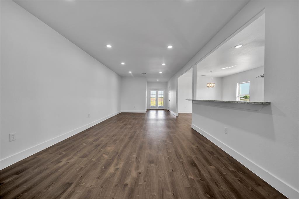 1128 Newton Road Ferris, TX 75125 - Photo 6 of 19 Unfurnished living room with recessed lighting, healthy amount of natural light, a chandelier, and dark wood-type flooring