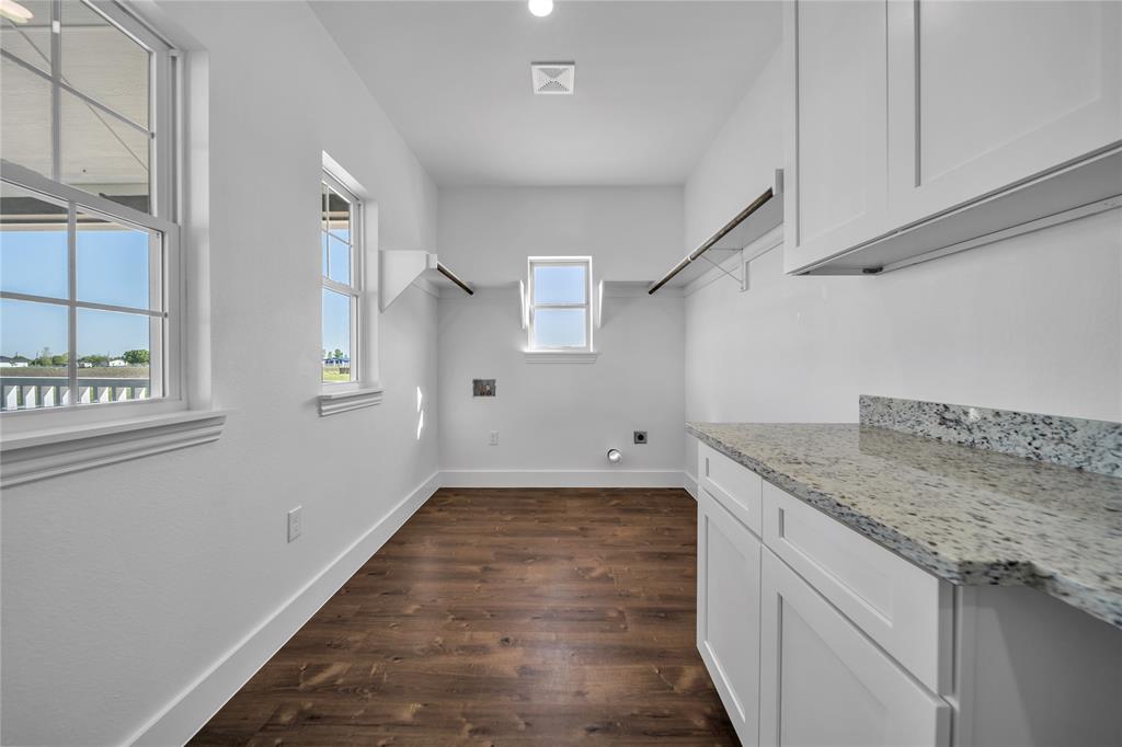 1128 Newton Road Ferris, TX 75125 - Photo 7 of 19 Laundry room featuring washer hookup, dark wood-style flooring, hookup for an electric dryer, and cabinet space