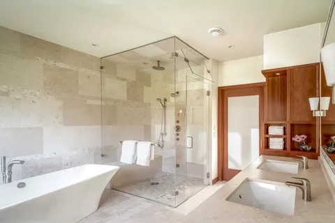 a white bath tub sitting in a bathroom next to a window