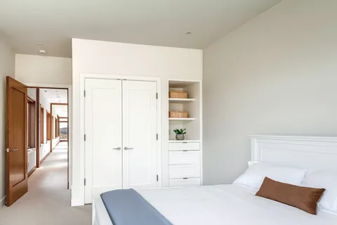 a bedroom with a large window and a bed