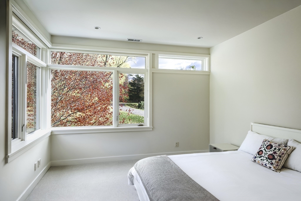 154 Argilla Road Ipswich, MA 01938 - Photo 30 of 42 a bedroom with a large window and a bed
