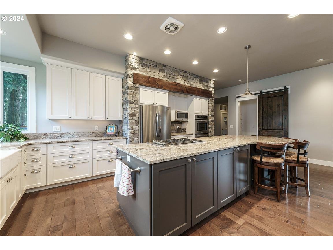 27015 Northeast Hathaway Road Camas, WA 98607 - Photo 15 of 48 a kitchen with kitchen island granite countertop a sink cabinets and stainless steel appliances