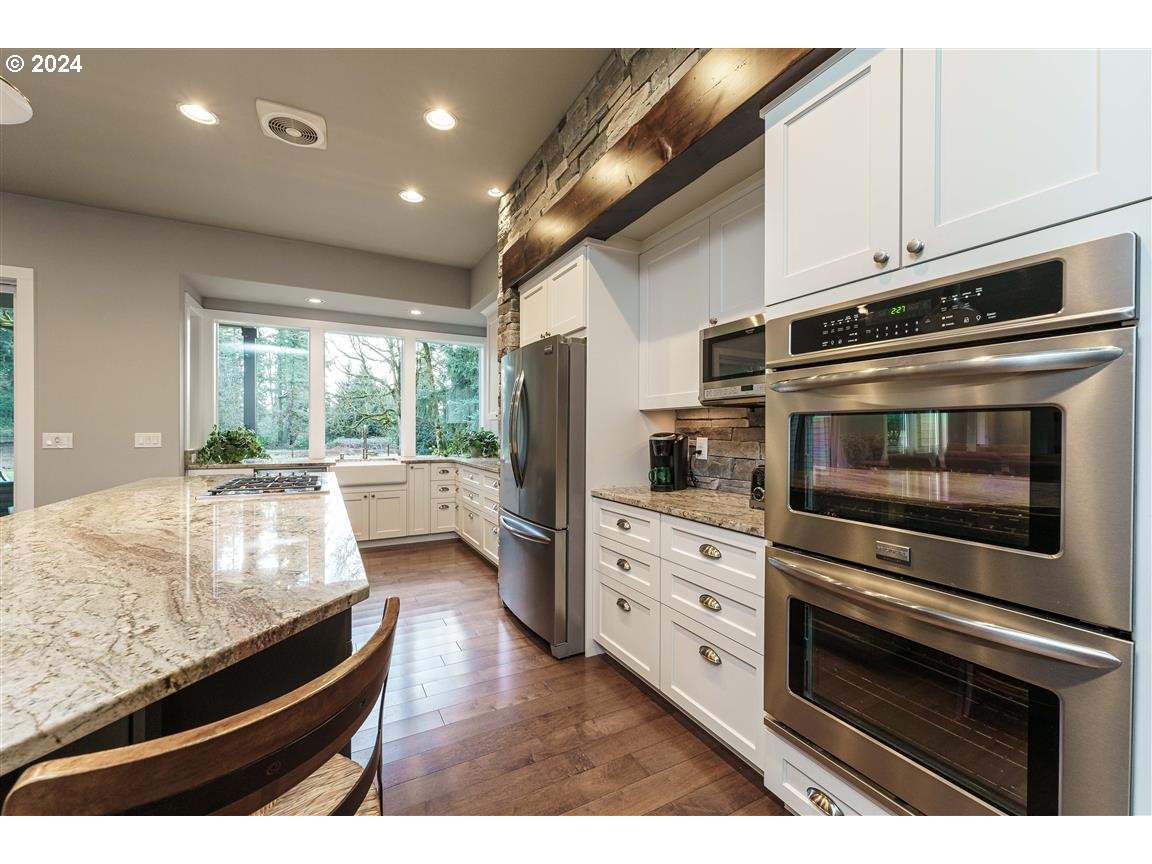 27015 Northeast Hathaway Road Camas, WA 98607 - Photo 10 of 48 a kitchen with stainless steel appliances kitchen island granite countertop a stove and cabinets