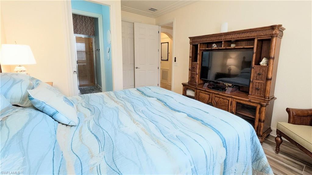 9081 Albion Lane South, Unit 6505 Naples, FL 34113 - Photo 17 of 41 a bedroom with a bed and a flat screen tv
