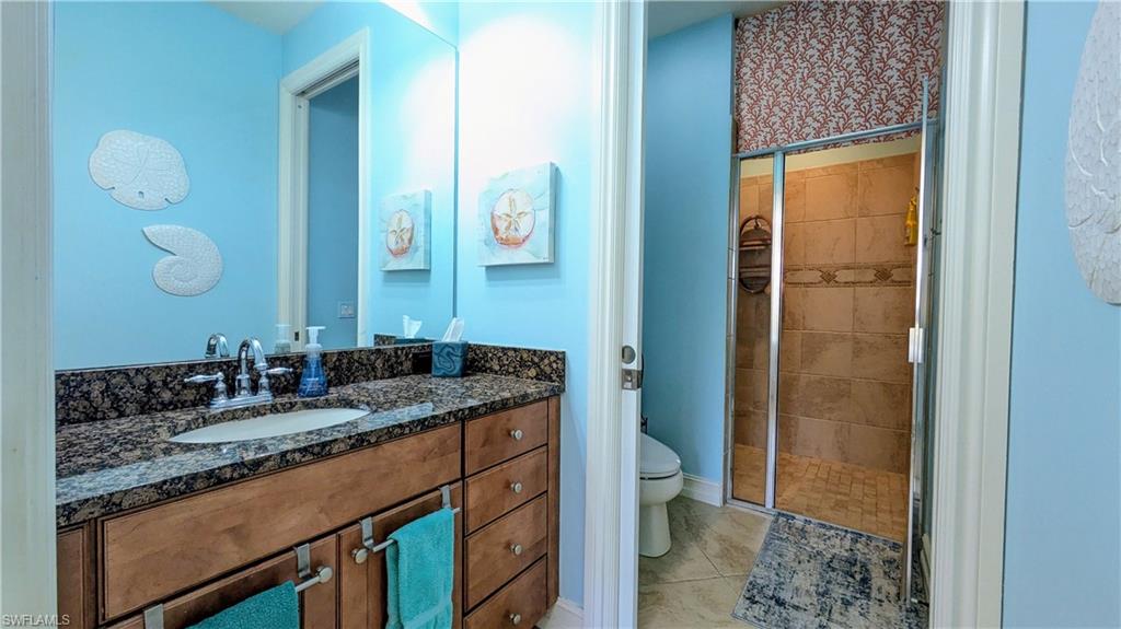 9081 Albion Lane South, Unit 6505 Naples, FL 34113 - Photo 19 of 41 a bathroom with a granite countertop sink and a mirror