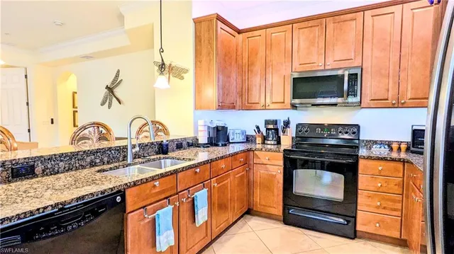 a kitchen with stainless steel appliances granite countertop a stove a sink and a microwave