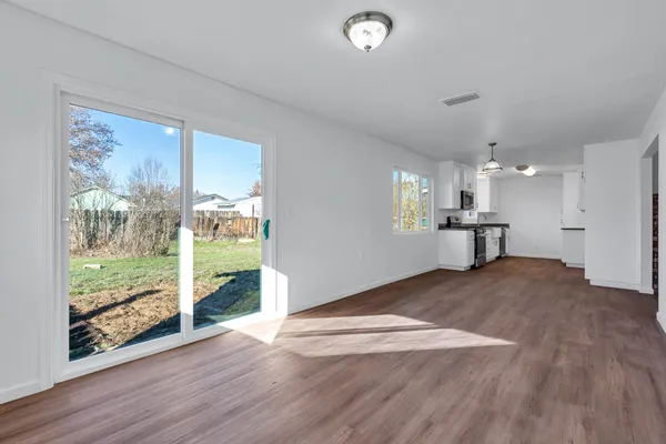 a view of a hallway with wooden floor and a large window