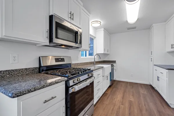 a kitchen with granite countertop a sink and a stove