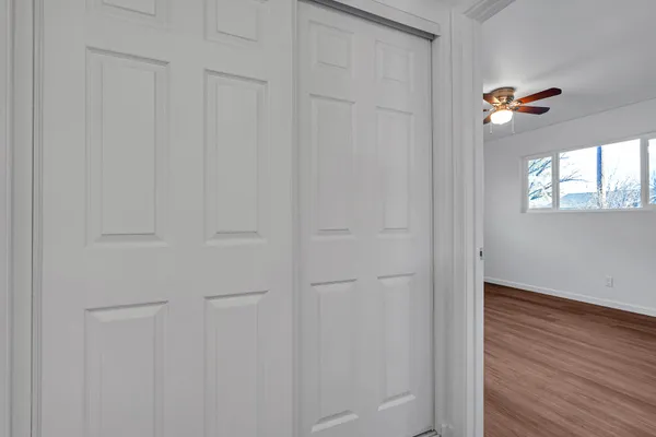 an empty room with wooden floor and windows