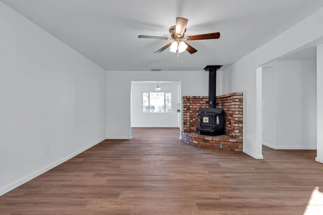 a view of a bedroom with wooden floor and window
