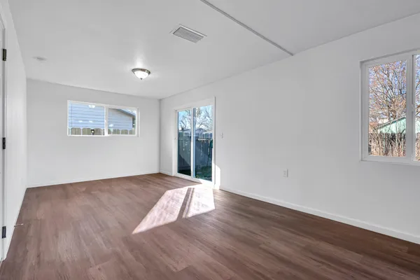 a view of a kitchen with wooden floor and a large window