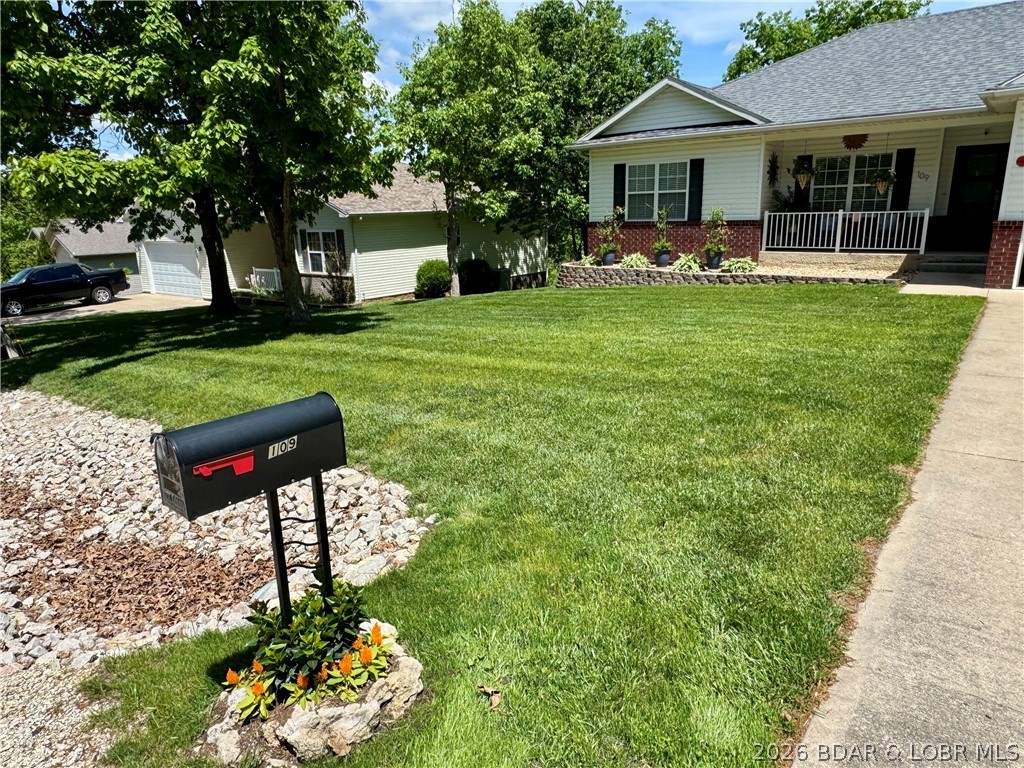 109 Reddington Road Four Seasons, MO 65049 - Photo 4 of 71 The expansive green lawn and tidy concrete drivewa