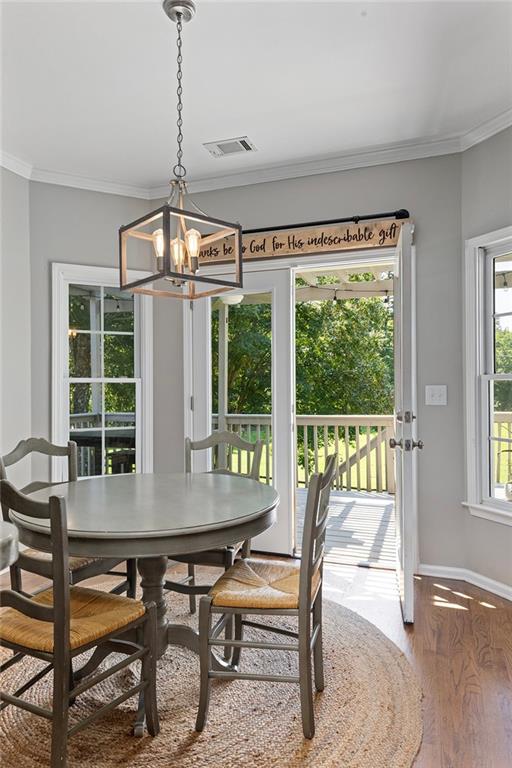 915 Taylor Parkway Suwanee, GA 30024 - Photo 20 of 61 a dining room with wooden floor a chandelier a glass table and chairs