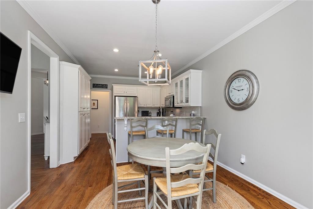 915 Taylor Parkway Suwanee, GA 30024 - Photo 21 of 61 a view of a dining room with furniture a chandelier and wooden floor