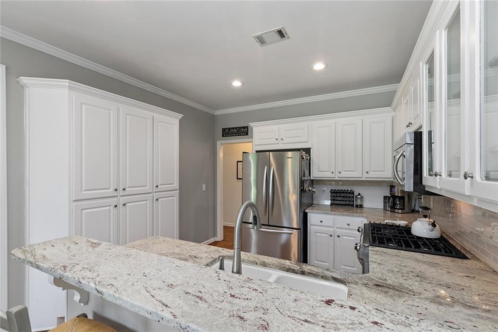 915 Taylor Parkway Suwanee, GA 30024 - Photo 22 of 61 a kitchen with stainless steel appliances granite countertop a refrigerator sink and stove