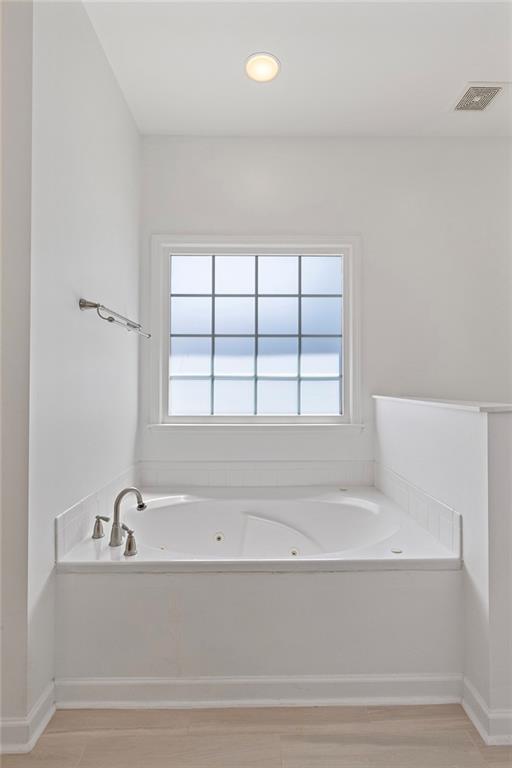 915 Taylor Parkway Suwanee, GA 30024 - Photo 37 of 61 a bathroom with a bathtub and next to a window