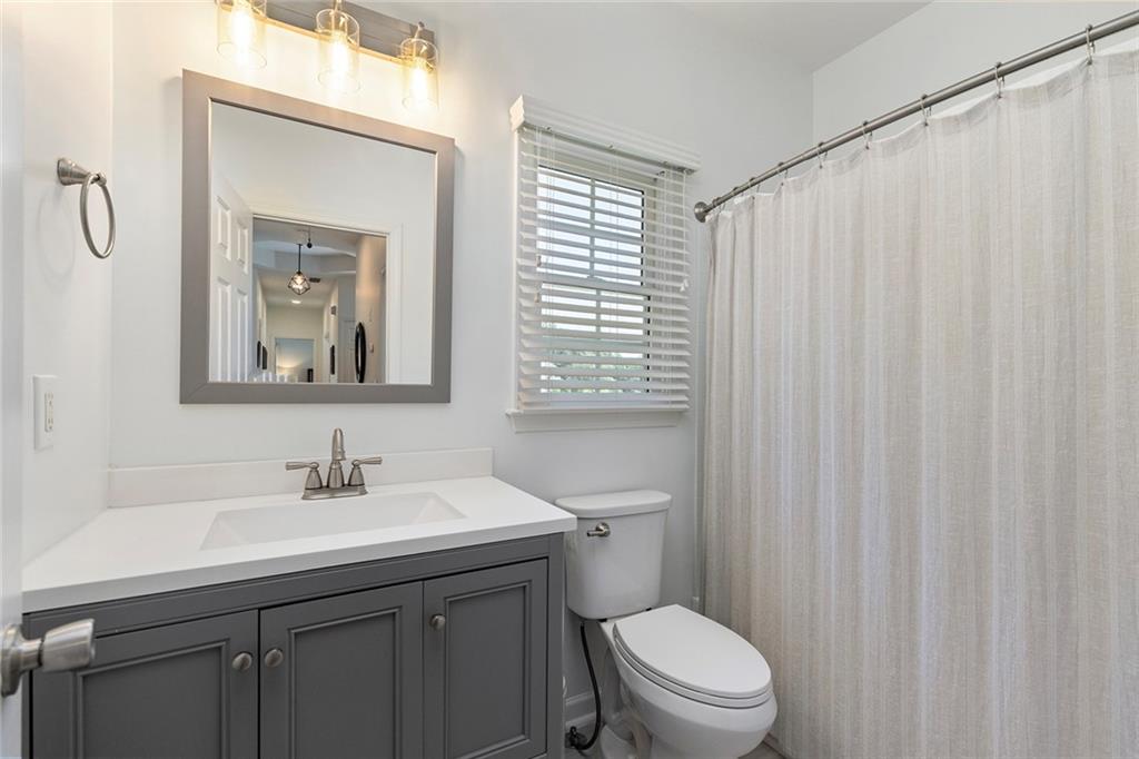 915 Taylor Parkway Suwanee, GA 30024 - Photo 40 of 61 a bathroom with a toilet a sink and a mirror