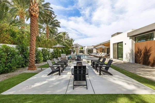 a view of a patio with table and chairs potted plants and large tree