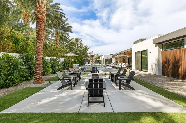 a view of a patio with table and chairs potted plants and large tree