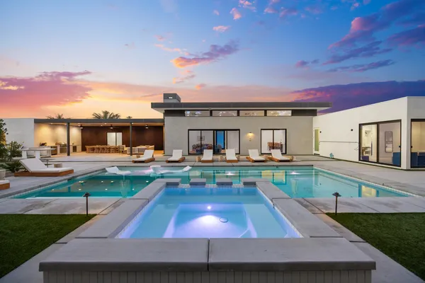 a swimming pool table and chairs in patio