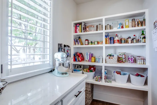 a kitchen with a lot of white cabinets and a wooden floor