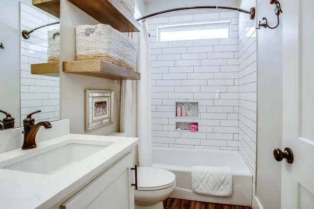a bathroom with a sink a toilet and shower