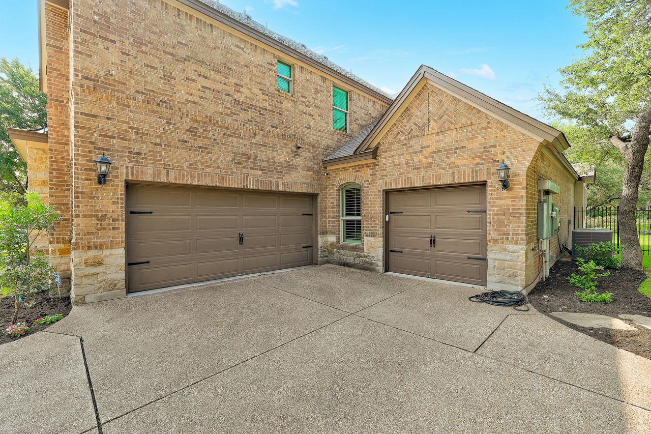 809 Prairie Dunes Drive Georgetown, TX 78628 - Photo 37 of 40 A broad, aggregate driveway leads to twin garages, complementing the brick and stone exterior of this stately home.