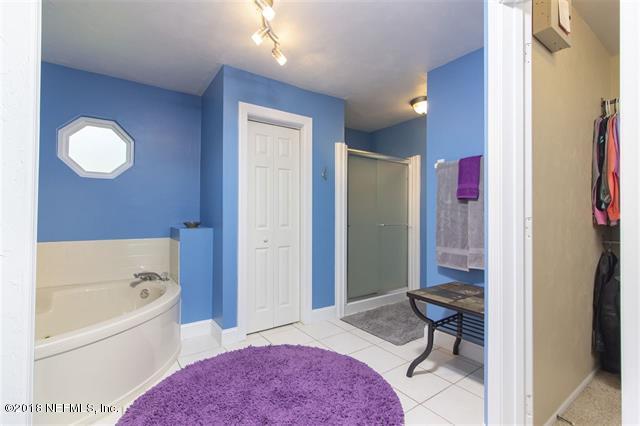 609 Queen Road St. Augustine, FL 32086 - Photo 13 of 35 a bathroom with a tub shower a mirror and a sink