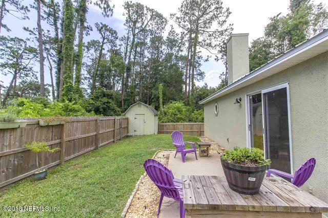 609 Queen Road St. Augustine, FL 32086 - Photo 23 of 35 a view of a backyard with table and chairs potted plants and tree