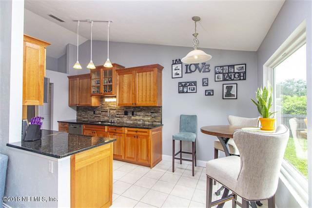 609 Queen Road St. Augustine, FL 32086 - Photo 33 of 35 a kitchen with stainless steel appliances granite countertop a sink a stove a dining table and chairs