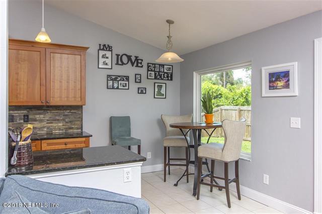 609 Queen Road St. Augustine, FL 32086 - Photo 6 of 35 a kitchen with stainless steel appliances granite countertop a stove top oven a dining table and chairs with wooden floor