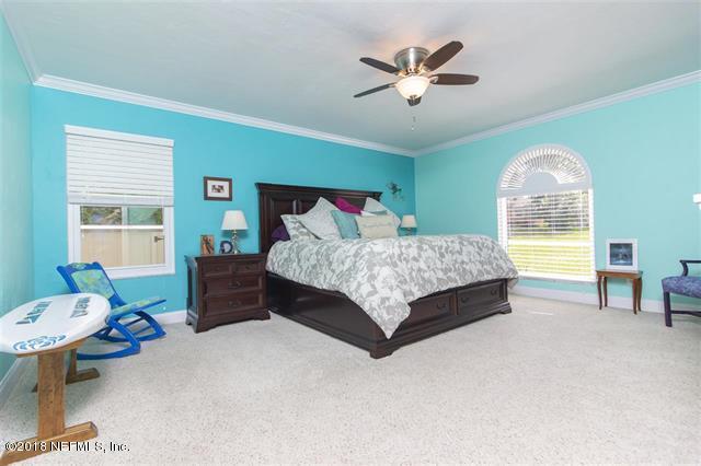609 Queen Road St. Augustine, FL 32086 - Photo 10 of 35 a bedroom with a bed and a chandelier