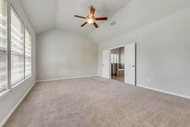 a view of a room with a ceiling fan and window