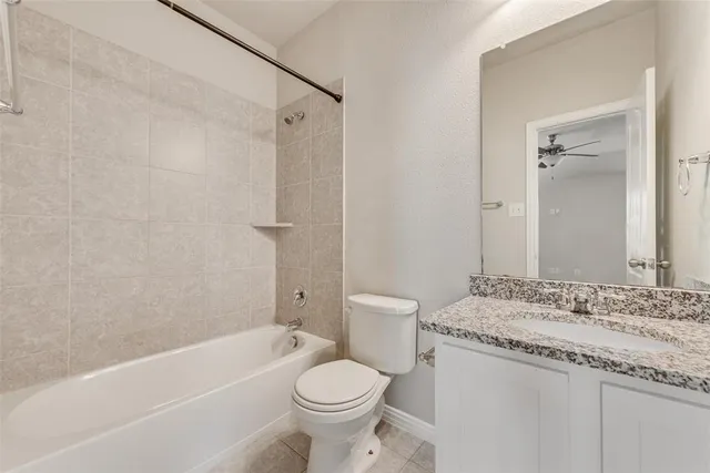 a bathroom with a granite countertop sink a toilet and shower