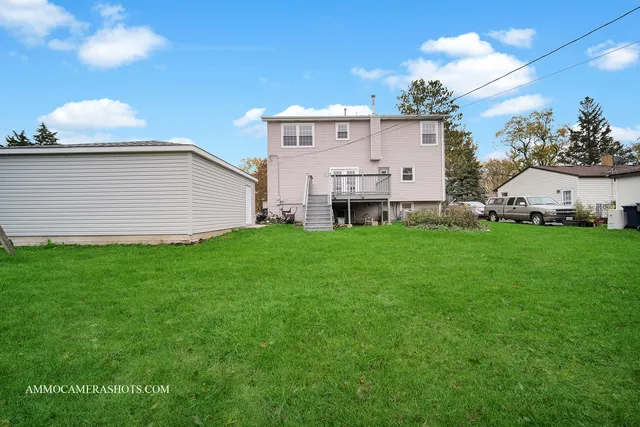 a view of a house with a backyard and a tree