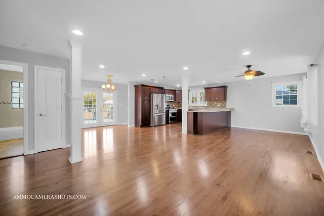 a view of a big room with wooden floor and a kitchen
