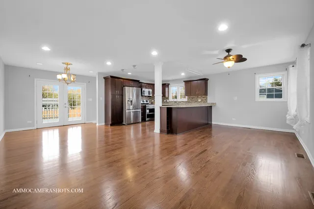 a view of a kitchen with refrigerator and wooden floor