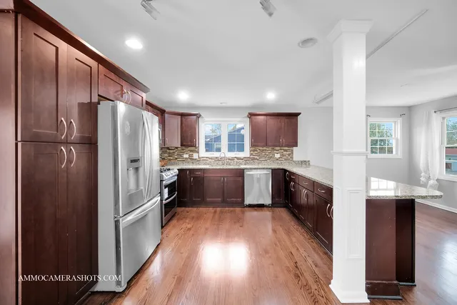 a kitchen with granite countertop stainless steel appliances and wooden cabinets