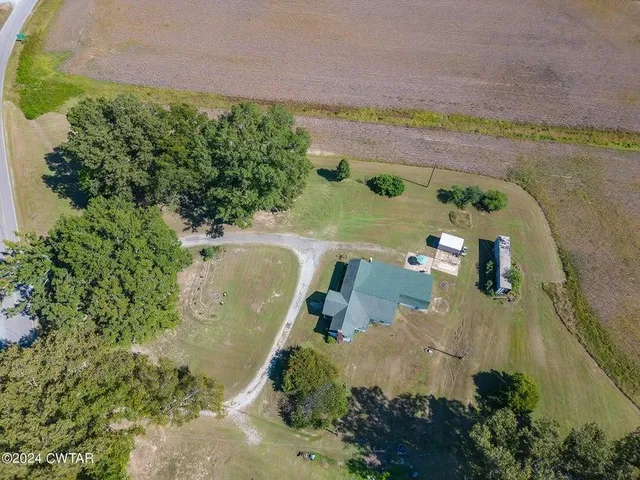 an aerial view of a house with a yard and lake view