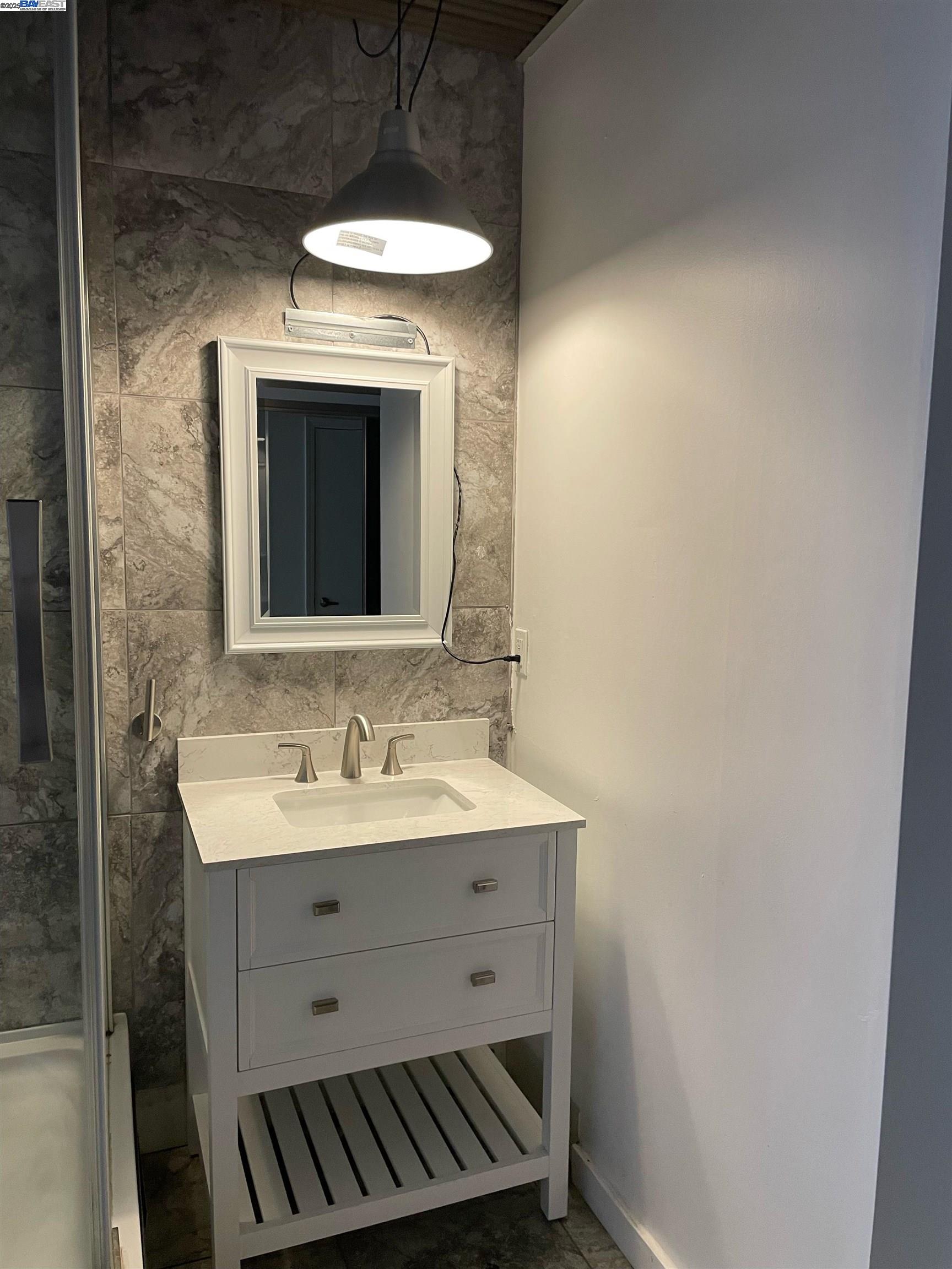 630 Thomas L Berkley Way, Unit 102 Oakland, CA 94612 - Photo 15 of 20 a bathroom with a sink and a mirror