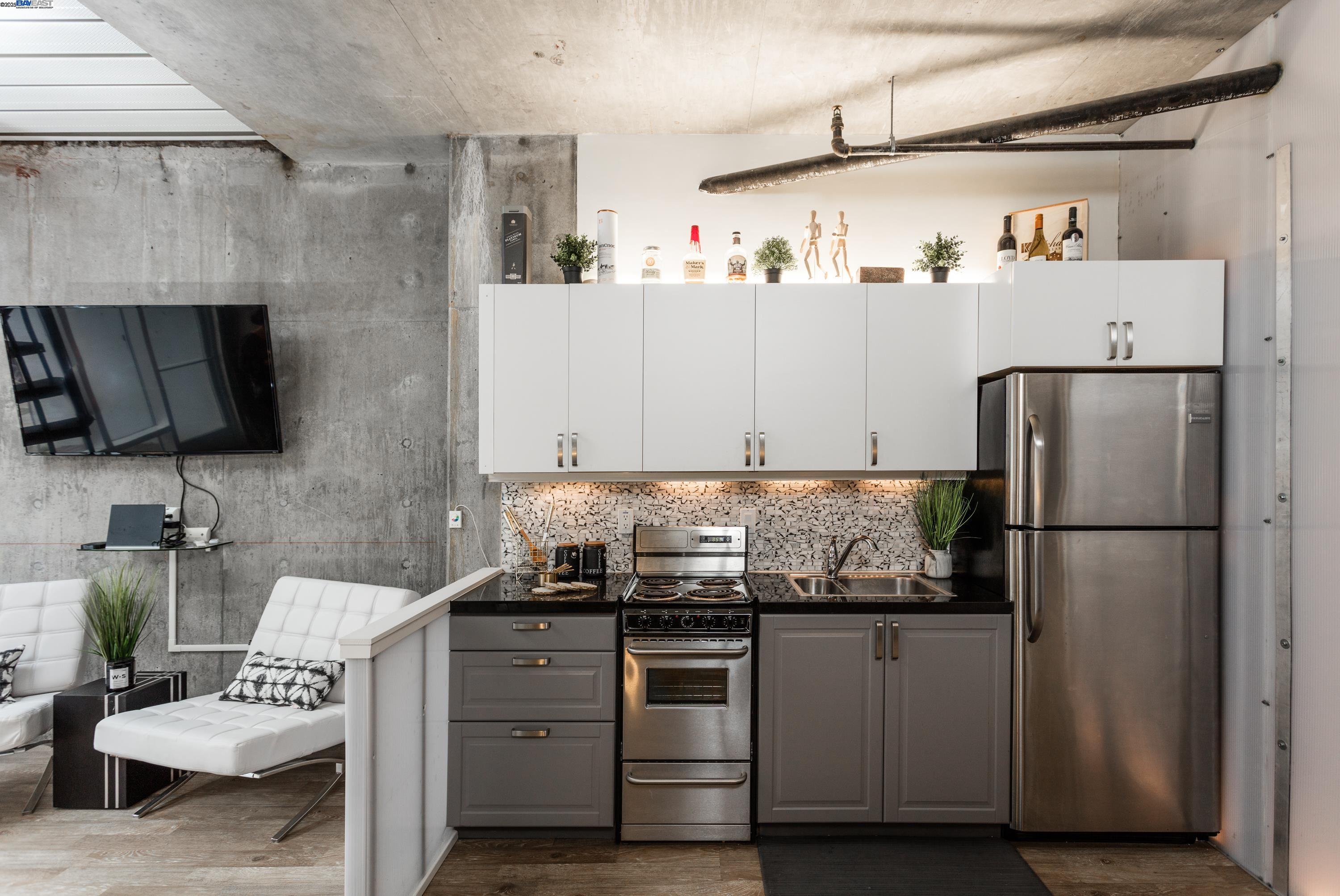 630 Thomas L Berkley Way, Unit 102 Oakland, CA 94612 - Photo 9 of 20 a kitchen with stainless steel appliances granite countertop a refrigerator and a stove