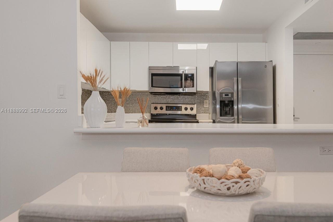 2301 Collins Avenue, Unit 333 Miami Beach, FL 33139 - Photo 11 of 37 a kitchen with a refrigerator and a stove top oven